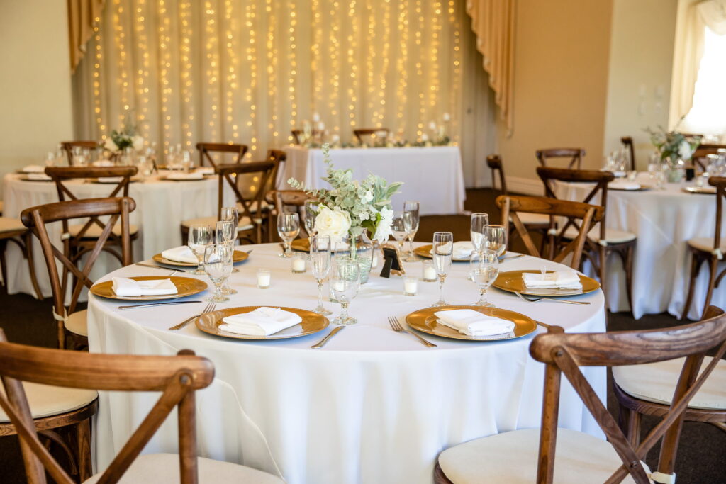 Close-up of wedding table setting with gold chargers, glassware, and floral centerpiece in an intimate Las Vegas reception venue