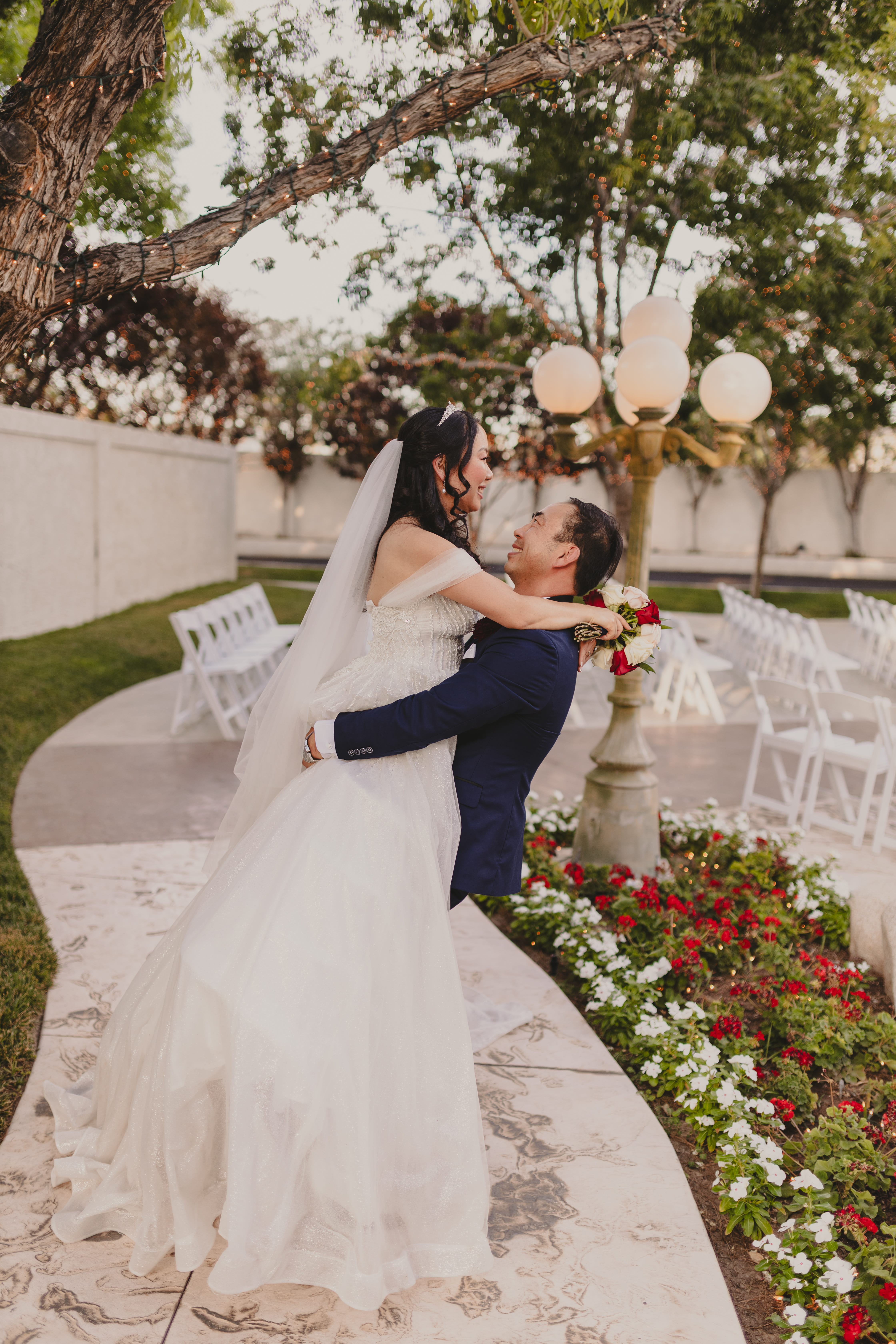 Bride and groom embracing under twinkle lights in a romantic outdoor Las Vegas wedding setting
