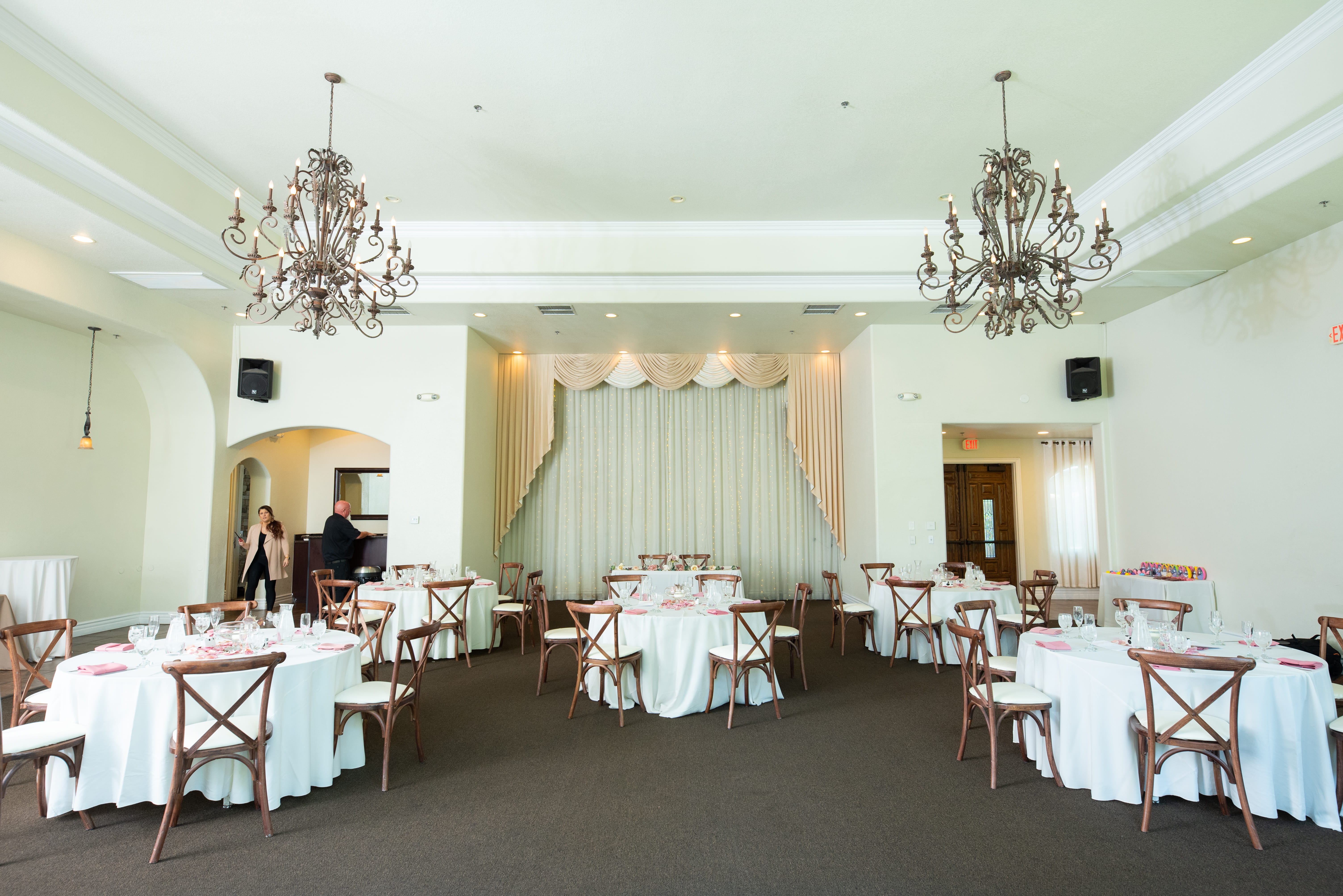 Elegant reception setup in The Sunset Room with draped backdrop, chandeliers, and seating for an intimate Las Vegas wedding