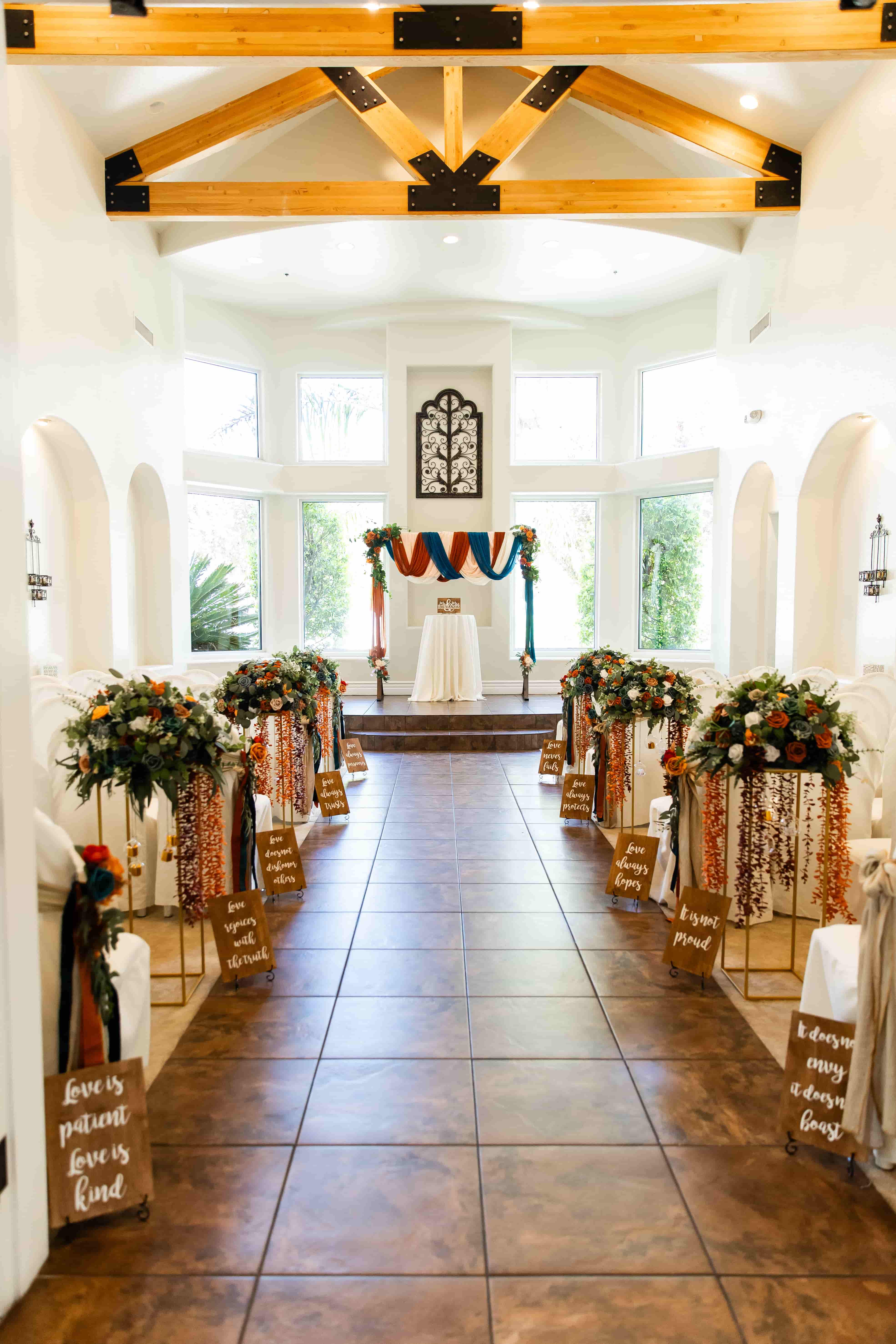 sunlit indoor wedding chapel in Las Vegas with floral ceremony arch and draping