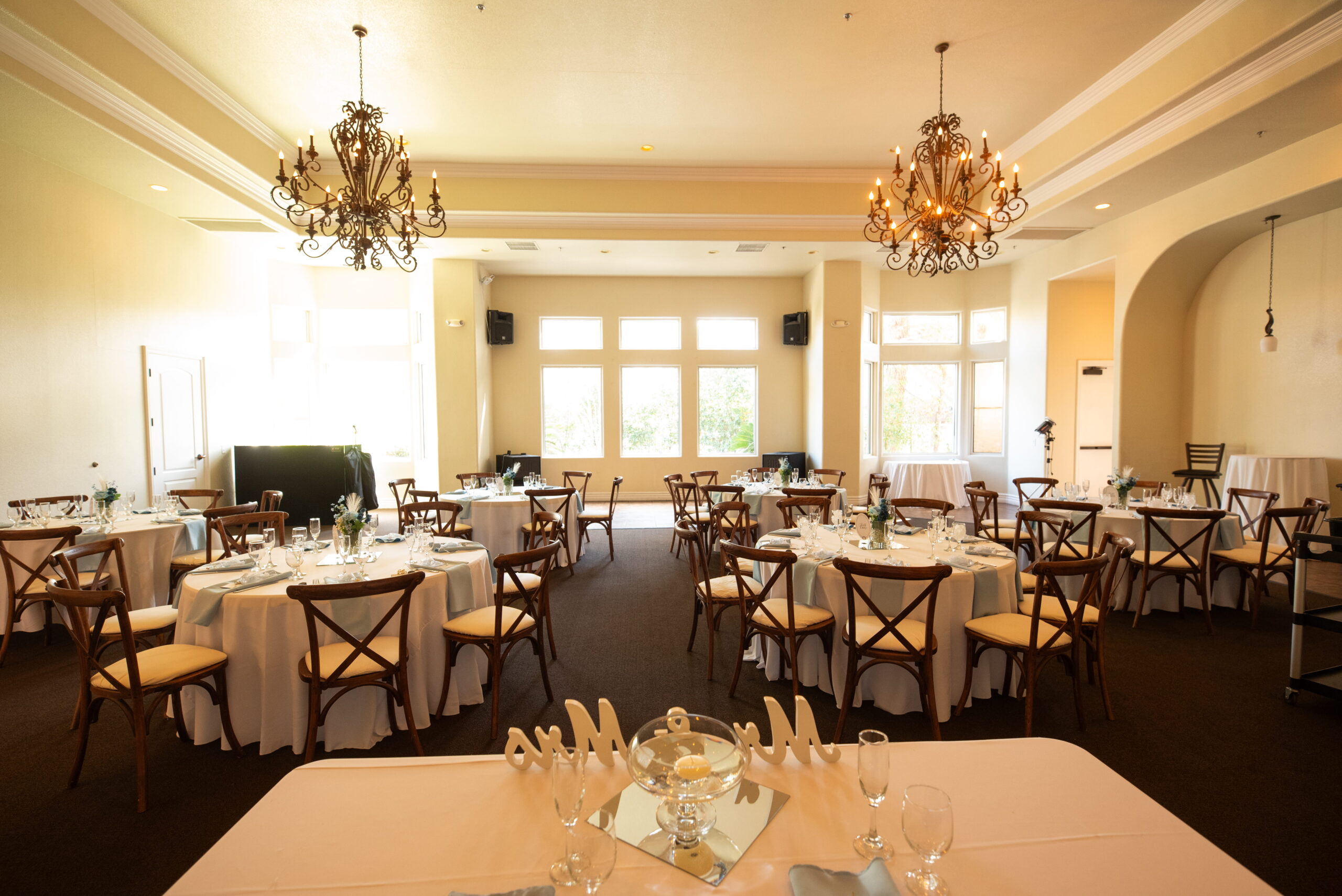 Wide view of The Sunset Room showing chandelier lighting, banquet tables, and airy layout for a small Las Vegas wedding