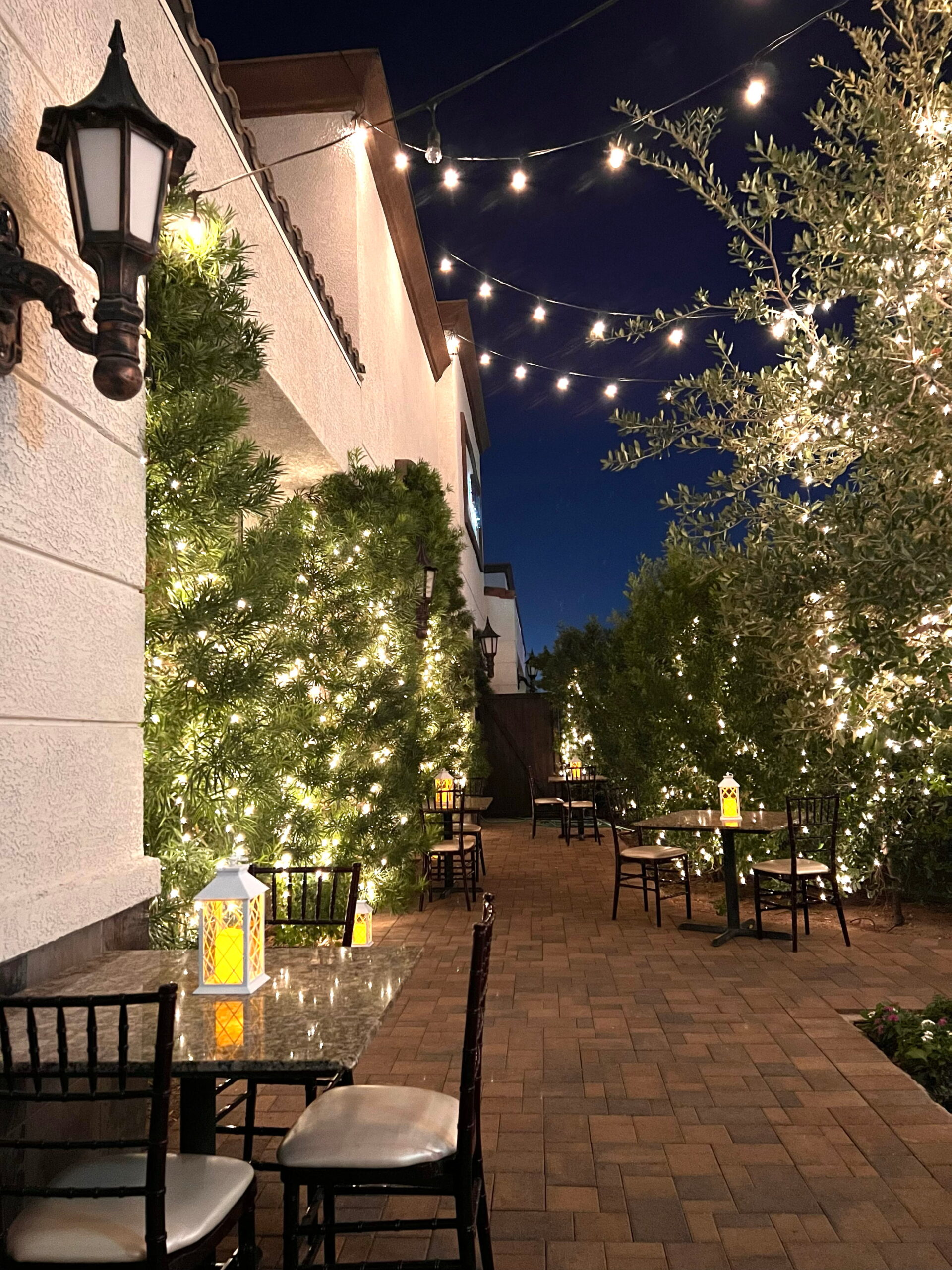 Outdoor patio at indoor wedding venue Las Vegas with string lights, greenery, and romantic evening ambiance  