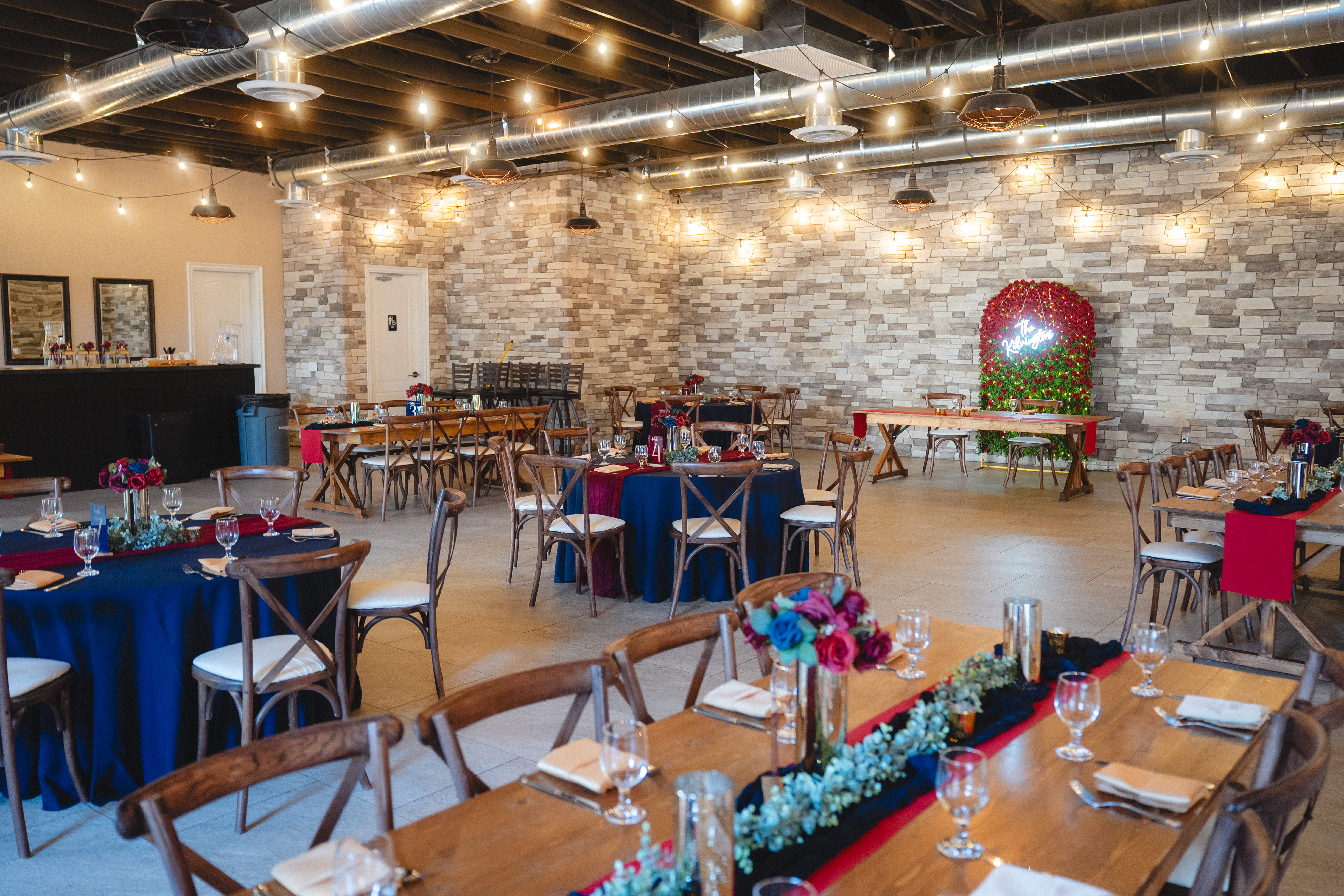 Indoor wedding venue Las Vegas reception layout with wood tables, colorful floral centerpieces, and modern decor 