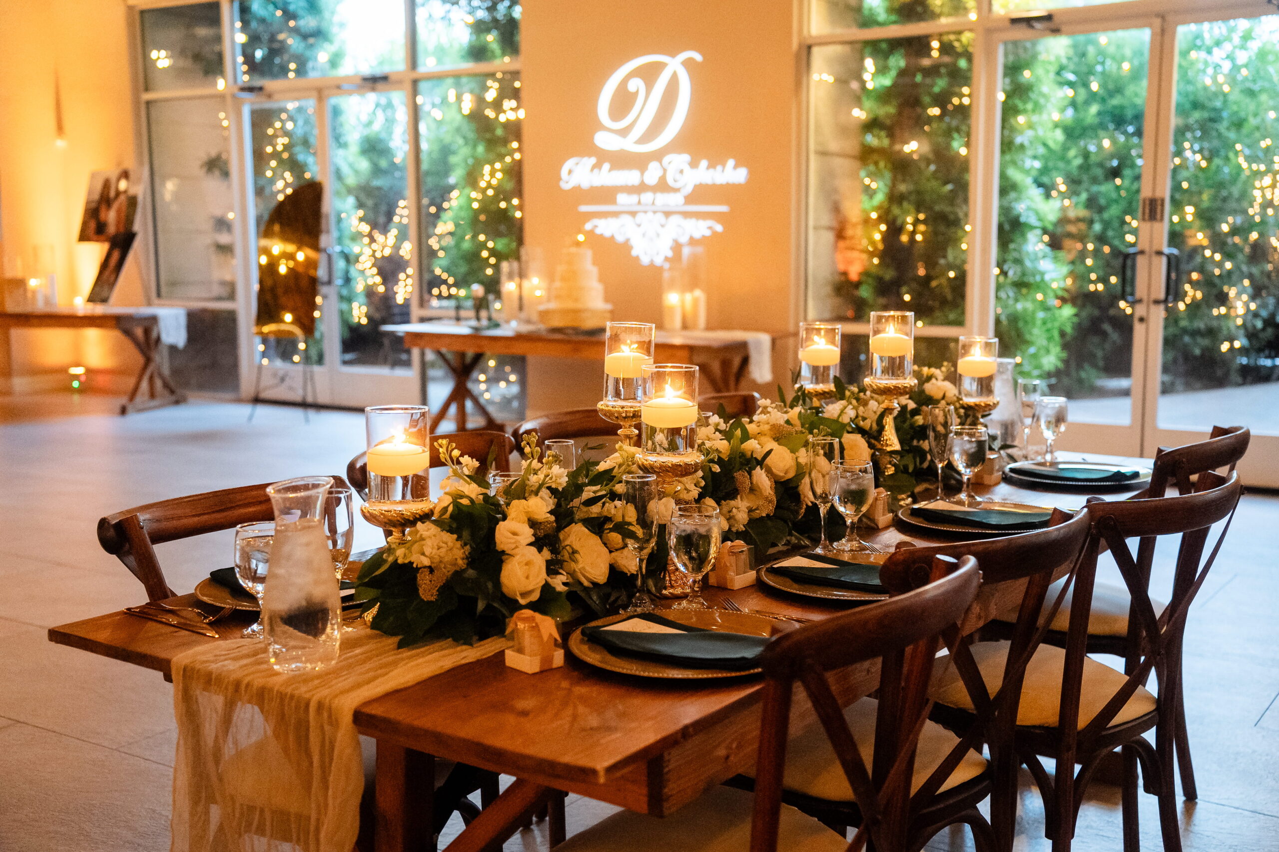 Romantic candlelit sweetheart table inside an indoor wedding venue in Las Vegas with floral arrangements and custom monogram