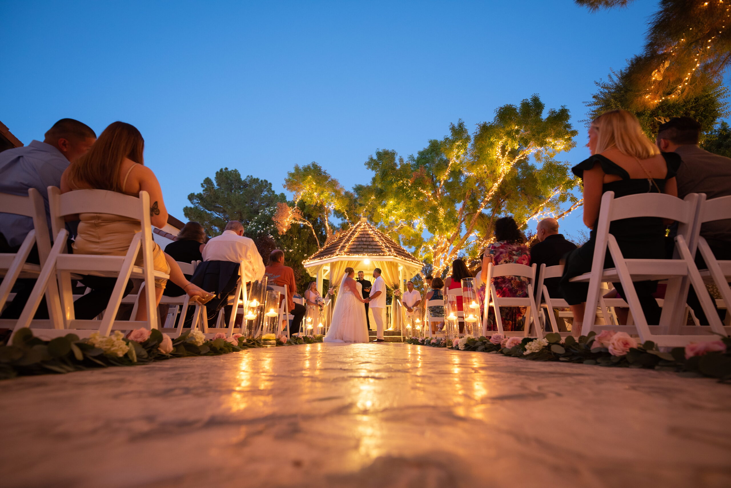 Outdoor ceremony aisle at sunset with guests seated at Las Vegas wedding venue