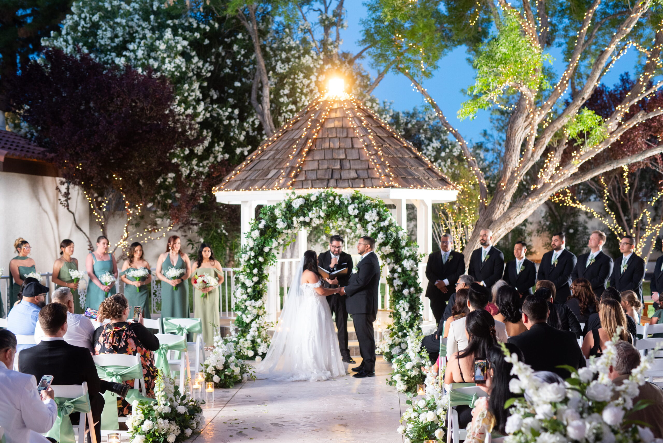 Garden ceremony with floral arch and wedding party at Las Vegas outdoor wedding venue