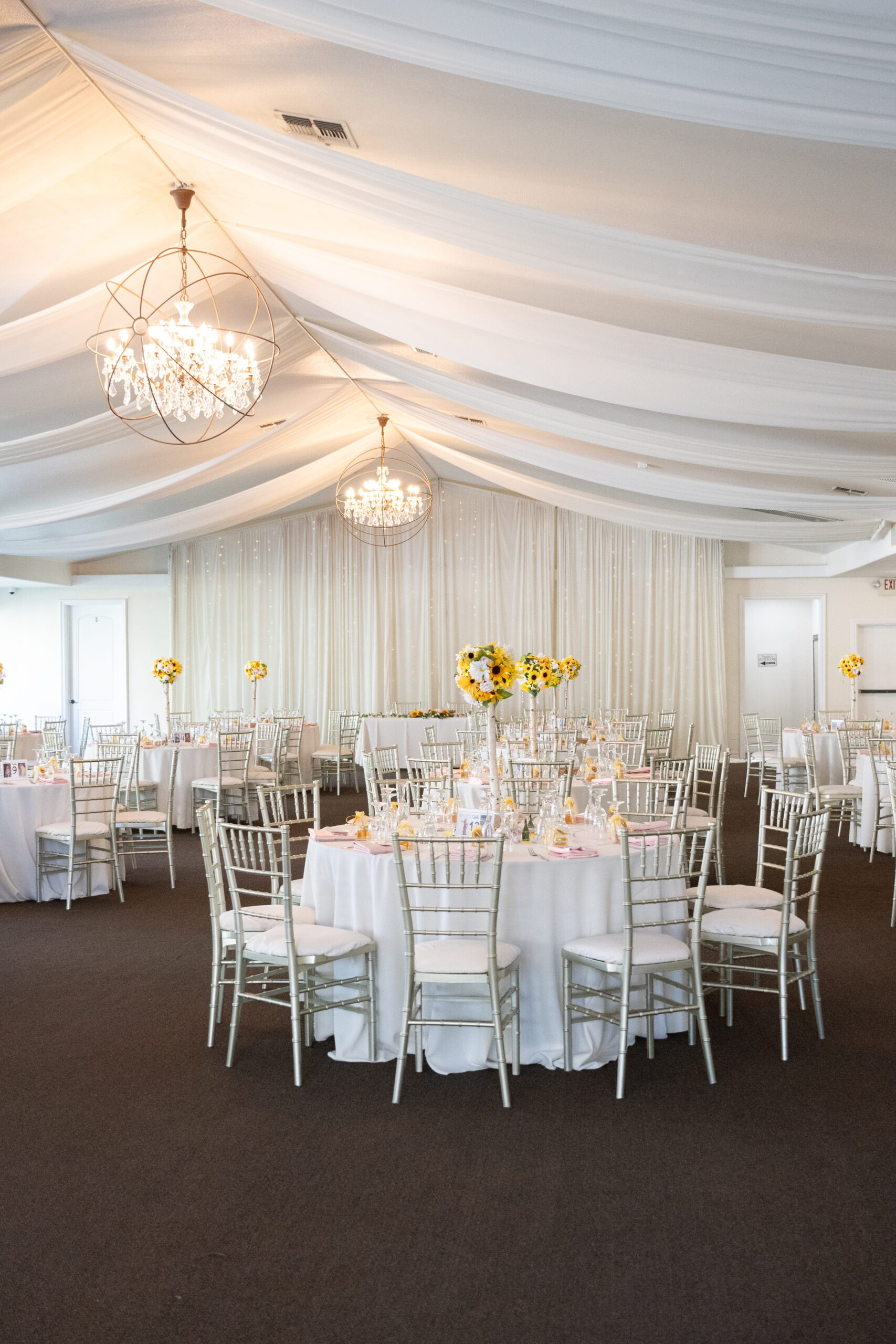 Garden Room reception tables with chandelier, wedding centerpieces, and draped ceiling Las Vegas