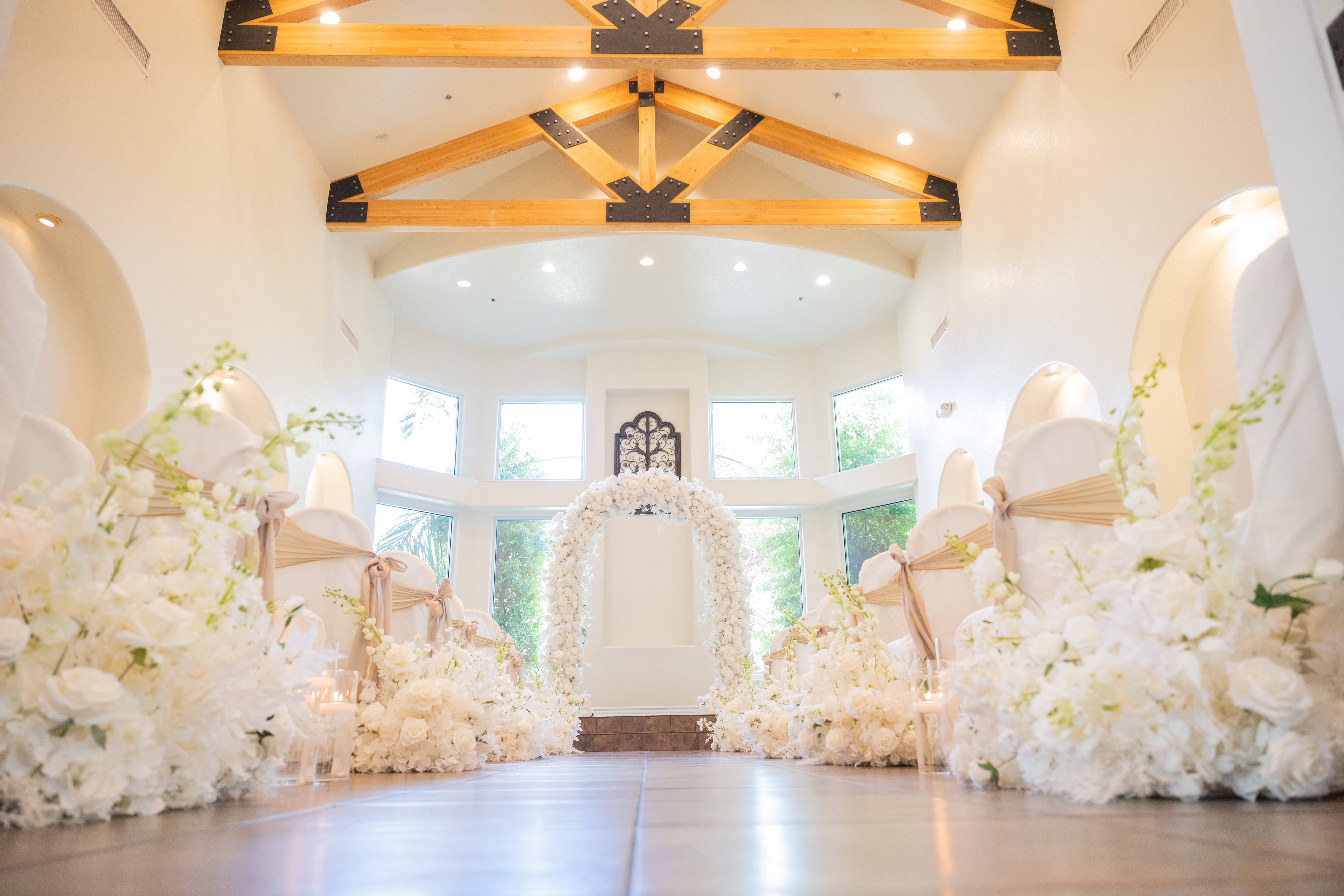 Elegant Las Vegas wedding chapel interior with wooden beams, floral-lined aisle, and ceremony altar