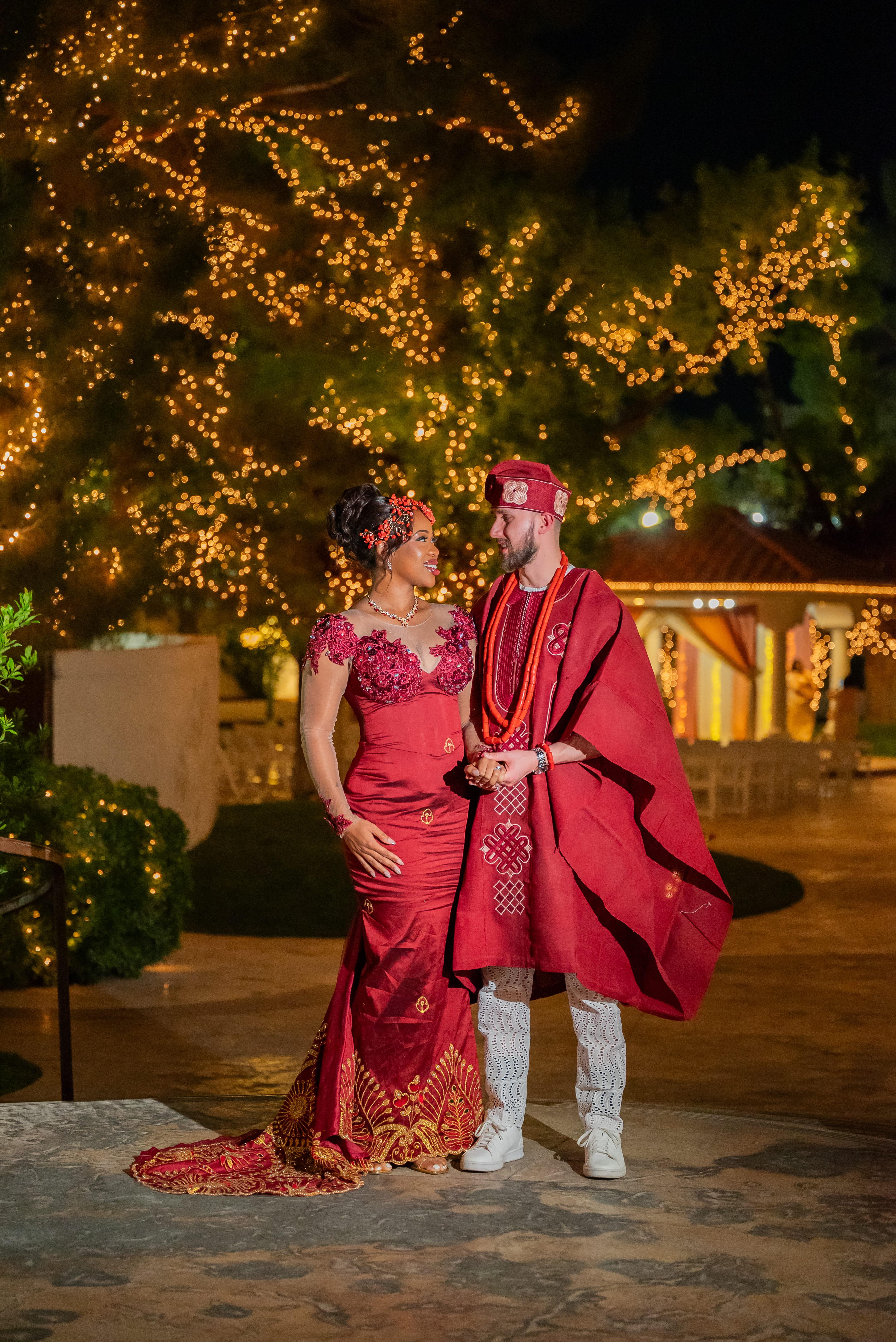 Couple in formal attire posing in front of illuminated trees during a nighttime Las Vegas wedding reception