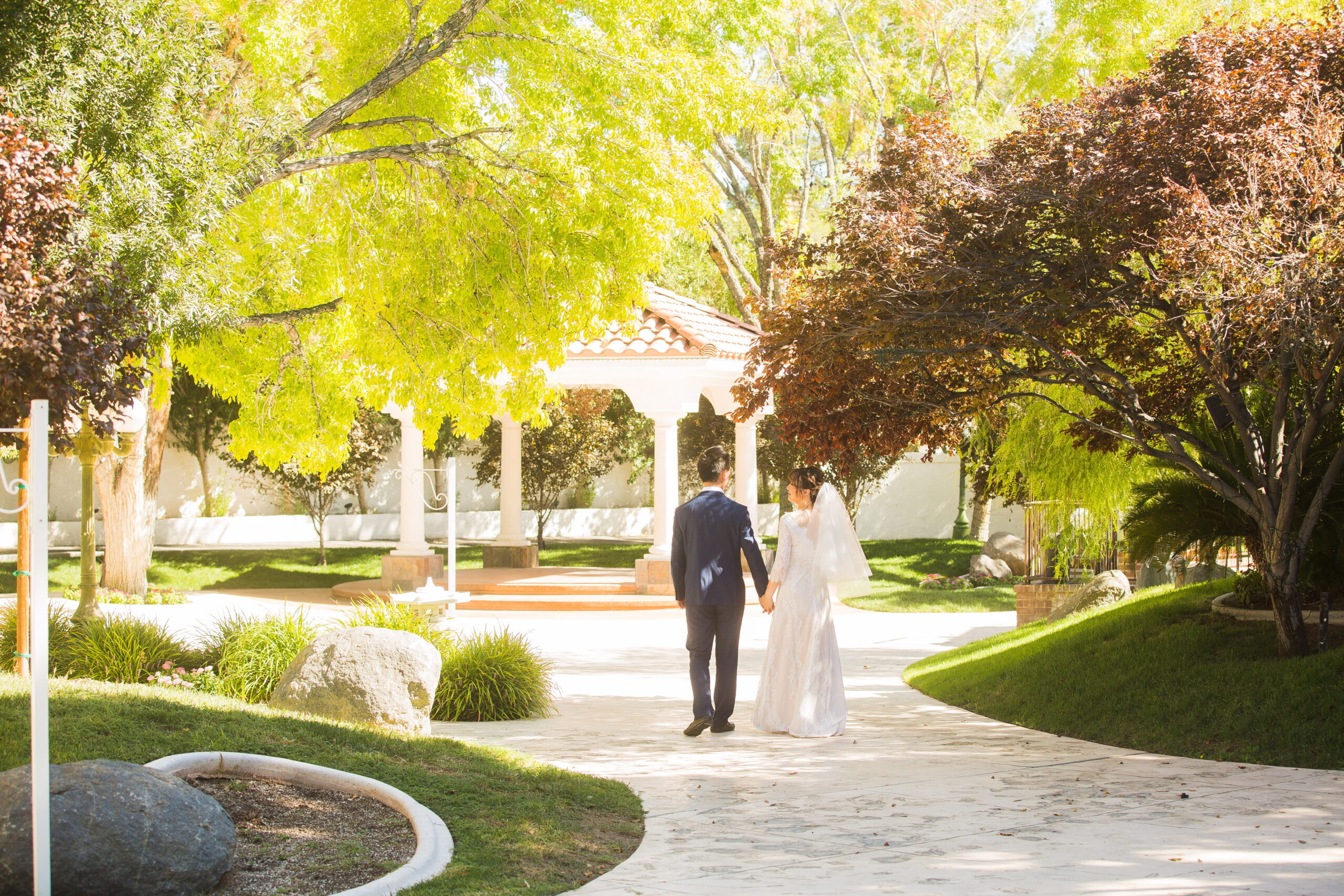 Bride and groom walking away together in a lush garden setting at a peaceful Las Vegas wedding venue