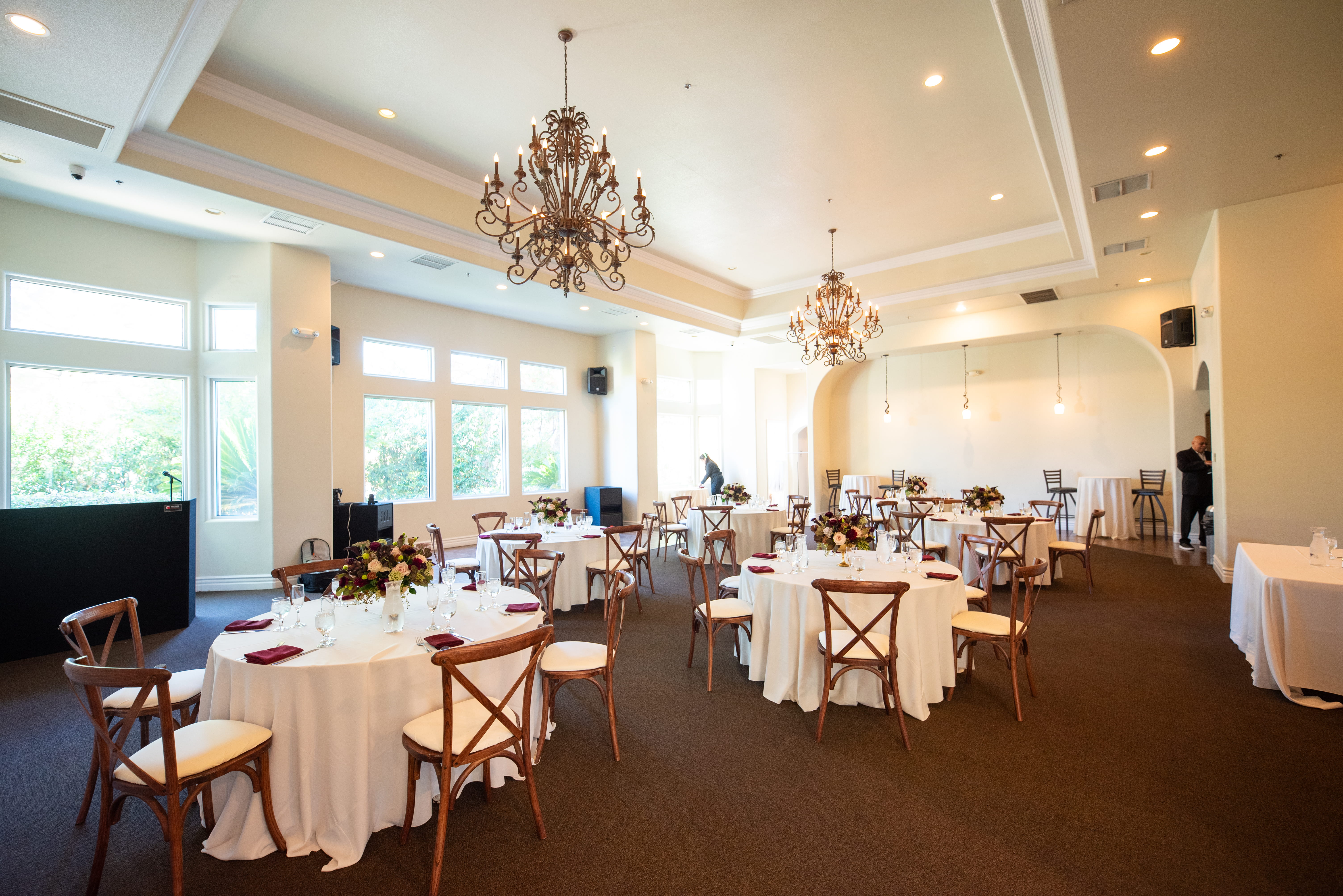 Bright indoor Las Vegas wedding venue with chandeliers, round tables, and natural light from large windows in The Sunset Room