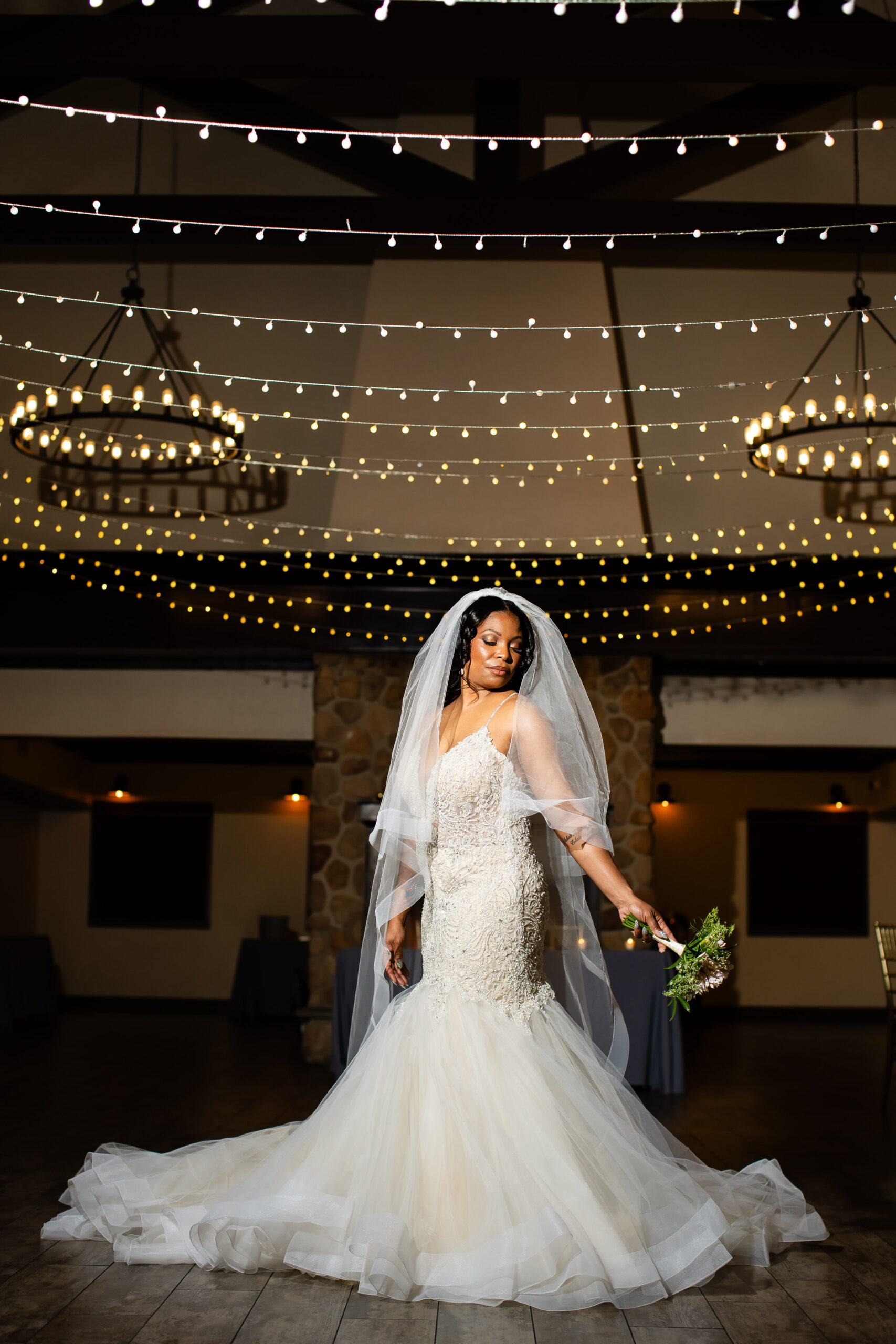 Las Vegas bride portrait indoors under warm string lights wearing a lace gown and veil