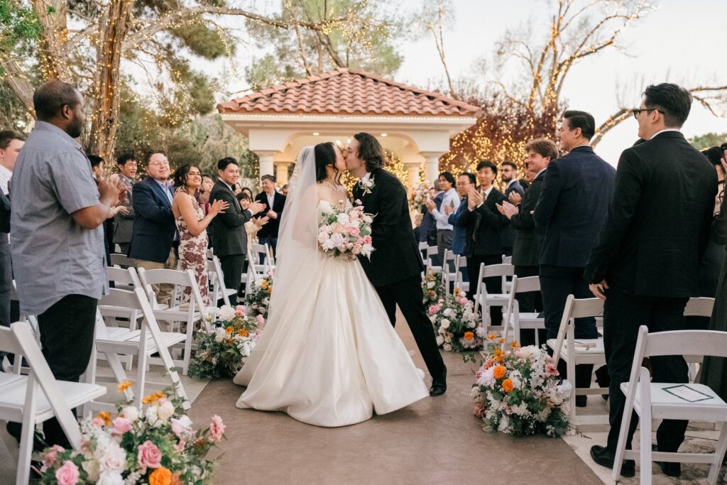 Bride and groom walking down the aisle after ceremony at a floral-lined Las Vegas wedding venue