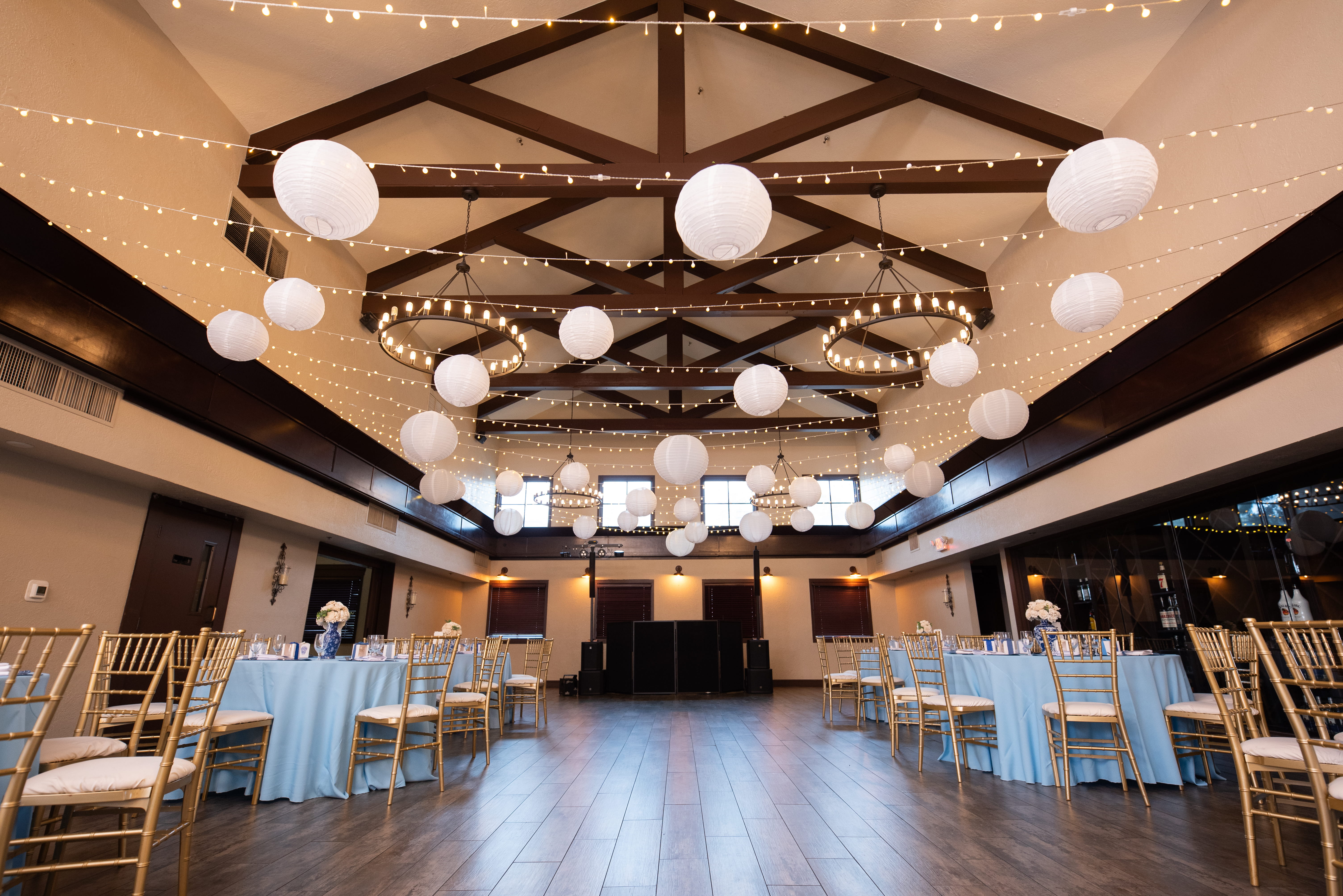 Las Vegas banquet hall reception setup with hanging paper lanterns, chandeliers, and wooden beam ceiling