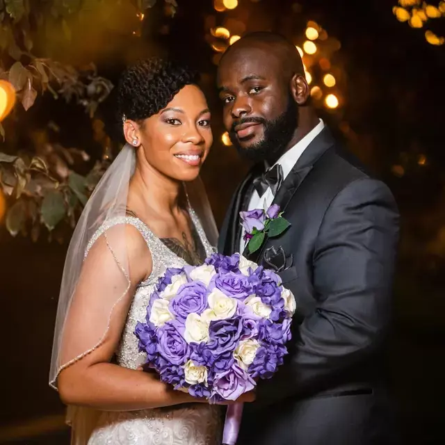 Joyful wedding couple posing with a floral bouquet at our garden venue in Las Vegas, known for personalized all-inclusive wedding packages