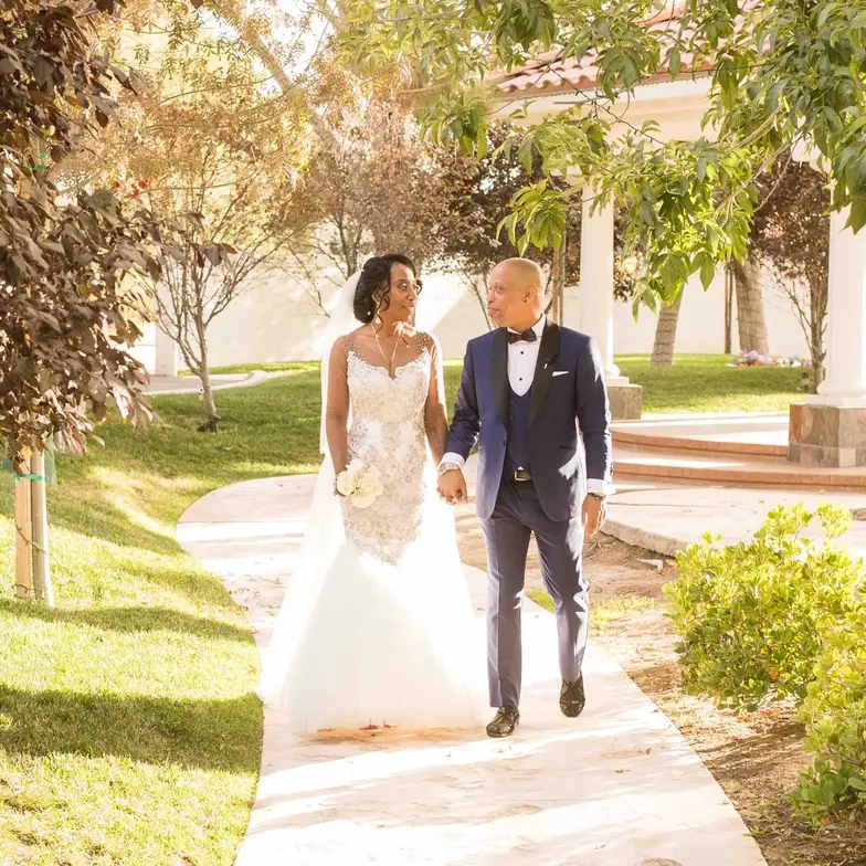 Couple walking on a path through the trees and gardens at Sunset Gardens, a romantic Las Vegas wedding venue and wedding chapel