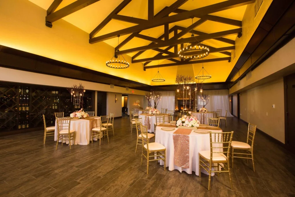 Outdoor-indoor wedding venue at The Side Yard with wooden beams, hanging lights, and a spacious open-air layout for private events.