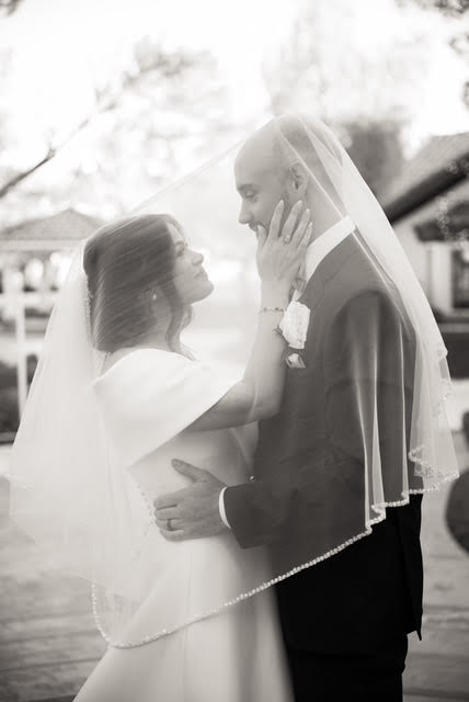 Black and white photo of bride and groom sharing an intimate moment under a veil at a Las Vegas wedding venue